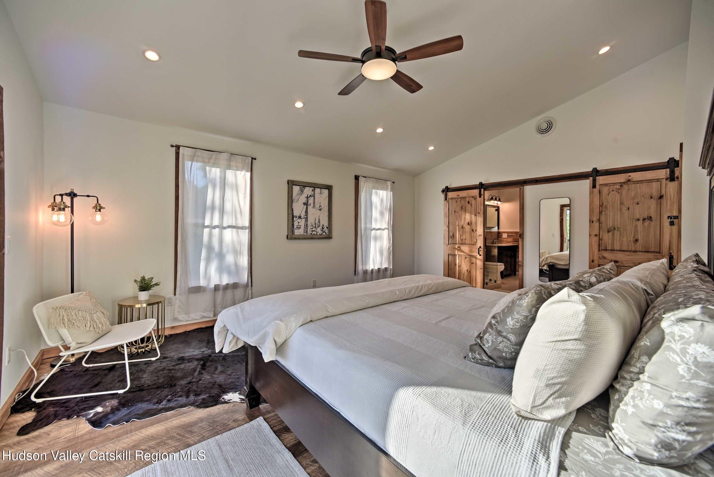 205 Nauvoo Road Windham, NY 12496 - Photo 29 of 31 a spacious bedroom with a bed a window and chair