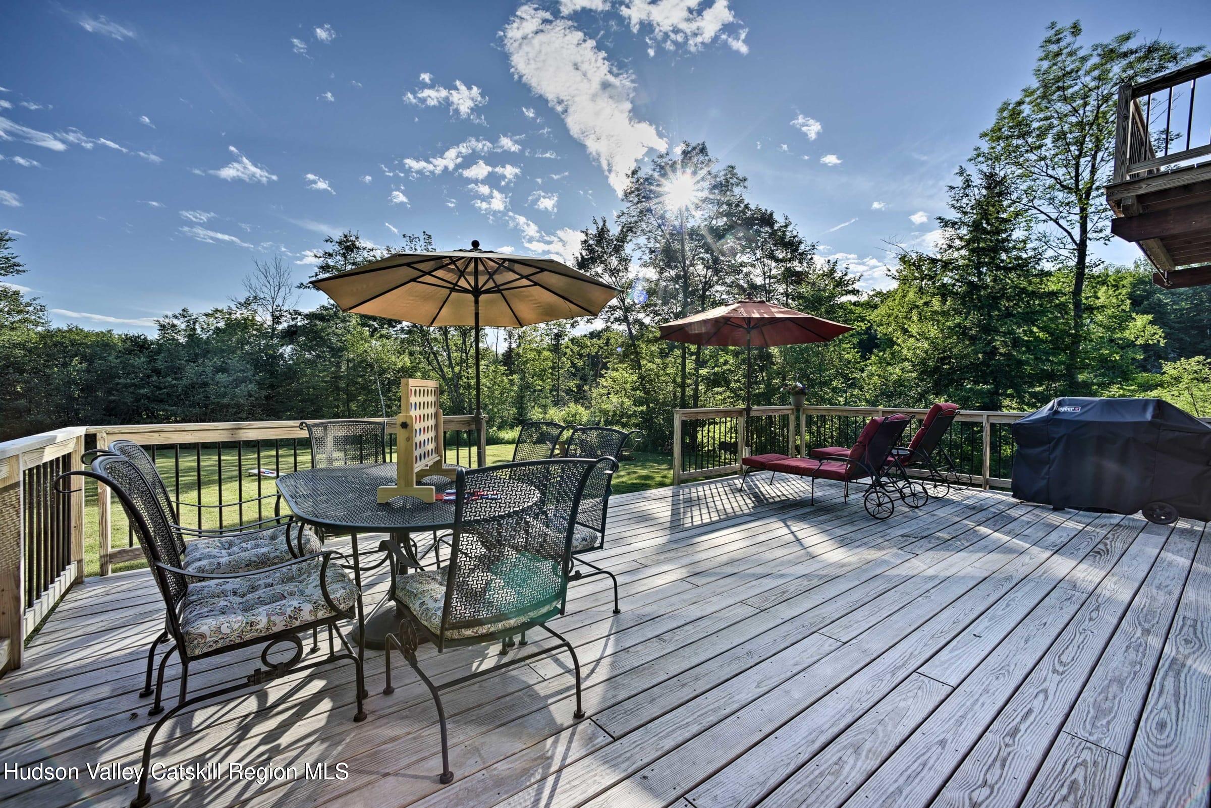 205 Nauvoo Road Windham, NY 12496 - Photo 5 of 31 a patio with wooden floor a yard a table and chairs