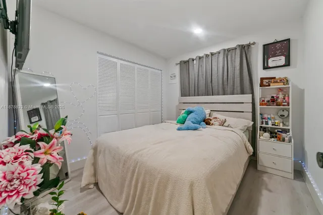 a bedroom with bed and a potted plant