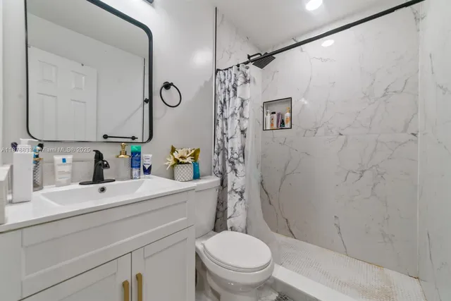 a bathroom with a sink toilet and shower