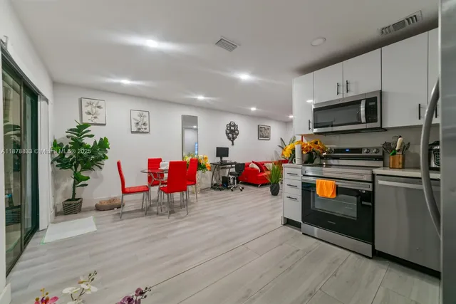 a kitchen with stainless steel appliances kitchen island granite countertop a stove and a wooden floors