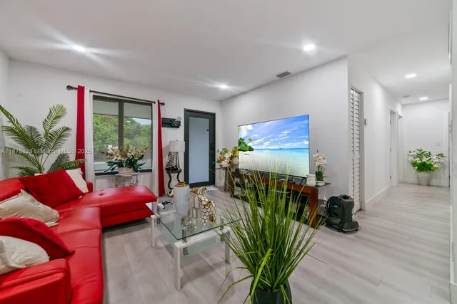 a living room with furniture floor to ceiling window and potted plant