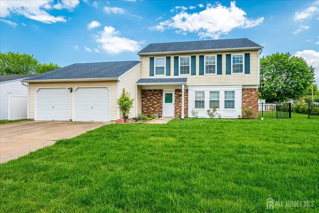 a front view of a house with a garden and yard