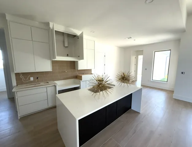 a kitchen with a sink cabinets and wooden floor