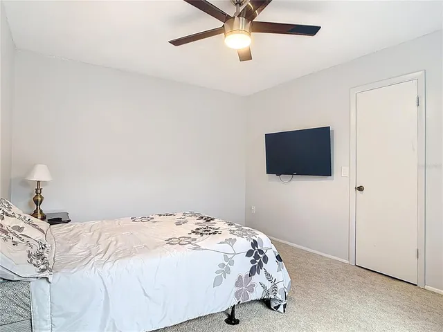 a bedroom with a bed and a ceiling fan