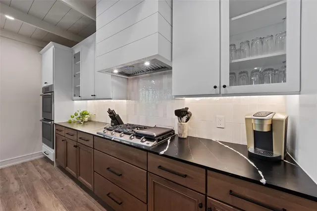 a kitchen with stainless steel appliances granite countertop a refrigerator and a stove top oven