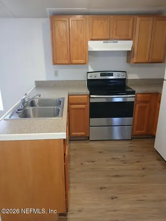 a kitchen with granite countertop a stove and a sink