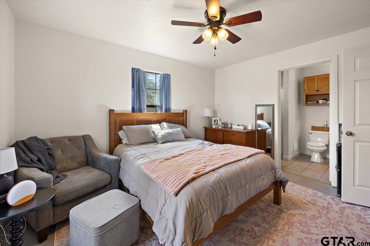 a bedroom with furniture and a ceiling fan