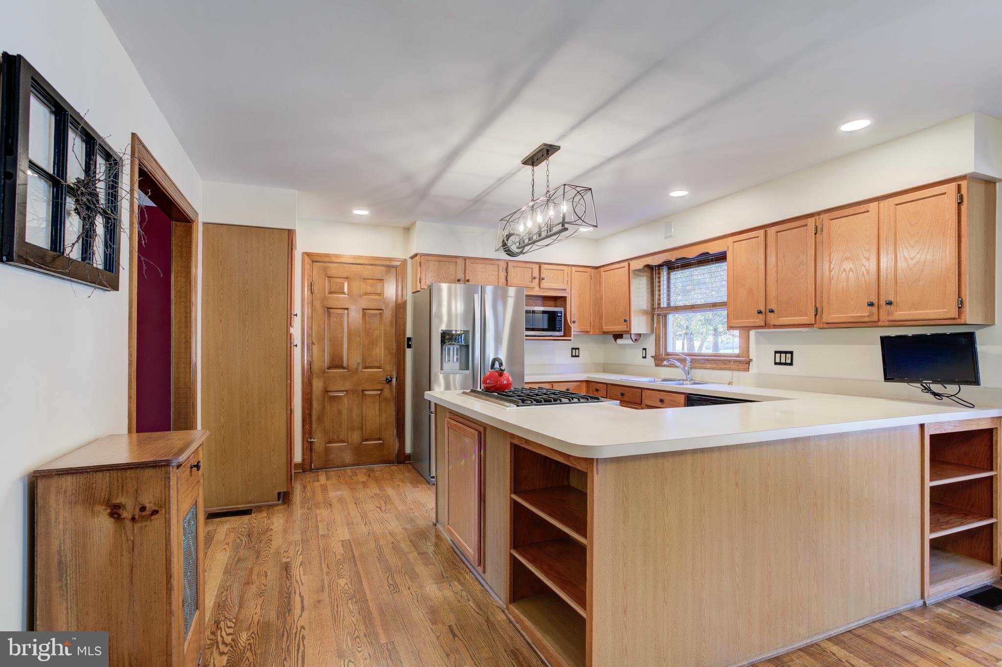 12117 Salem Church Road King George, VA 22485 - Photo 15 of 34 a kitchen with kitchen island a stove a refrigerator sink cabinets and wooden floor