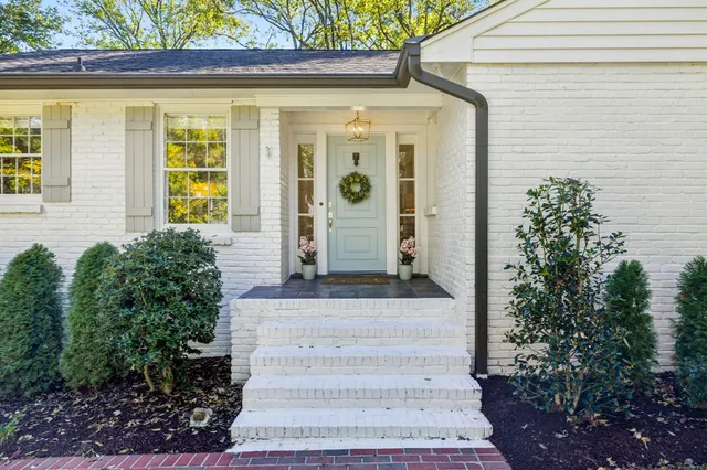 a front view of a house with plants