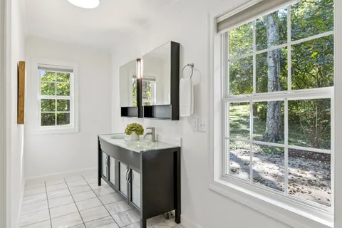 an empty room with wooden floor exposed radiator and windows