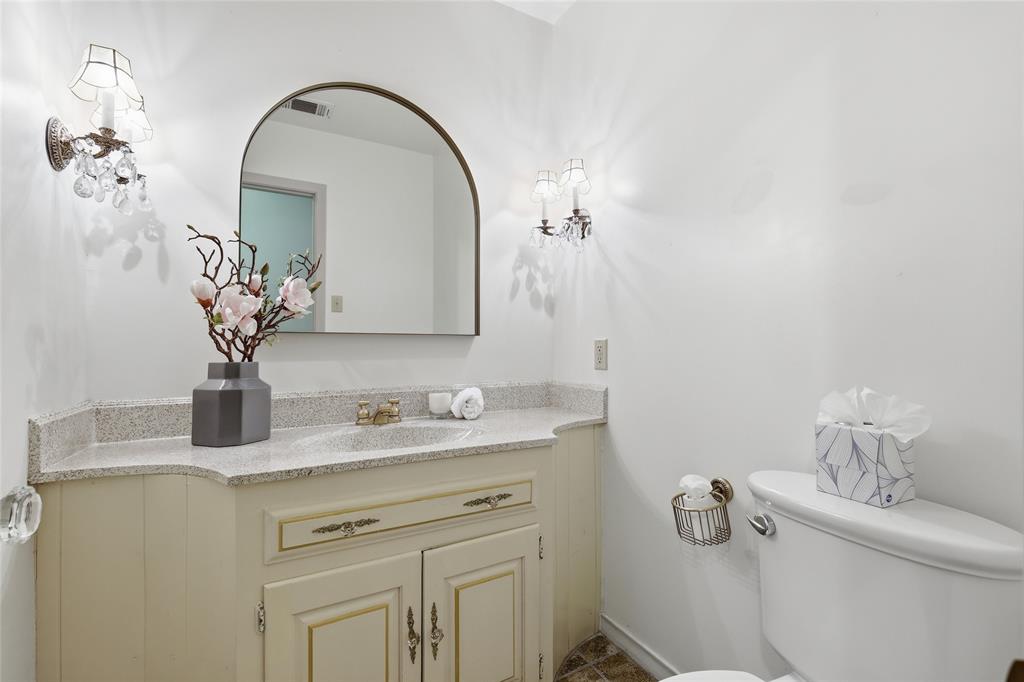 823 Ridgecrest Circle Denton, TX 76205 - Photo 16 of 40 Bathroom vanity featuring a speckled countertop and an integrated sink with a brass-finish faucet