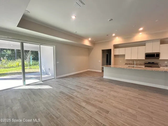 a view of kitchen with stainless steel appliances granite countertop a stove top oven a sink with granite countertops and cabinets