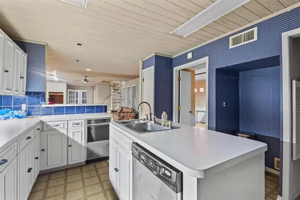 a kitchen that has a sink a stove and a table in it