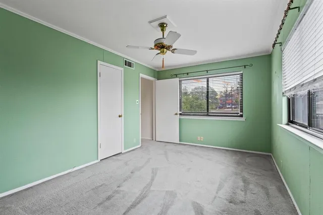 a view of a room with a window and a ceiling fan
