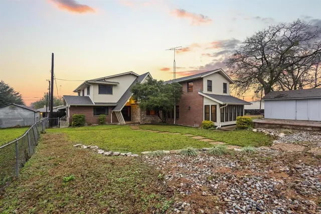 a front view of a house with a garden and trees