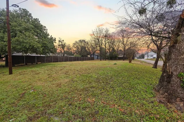 a view of a field with trees in the background