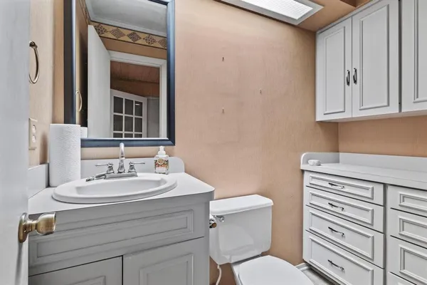 a bathroom with a sink a toilet and mirror