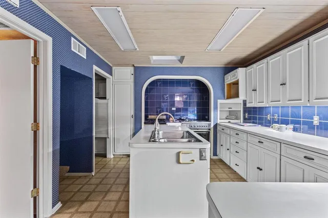 a kitchen with sink a stove and cabinets