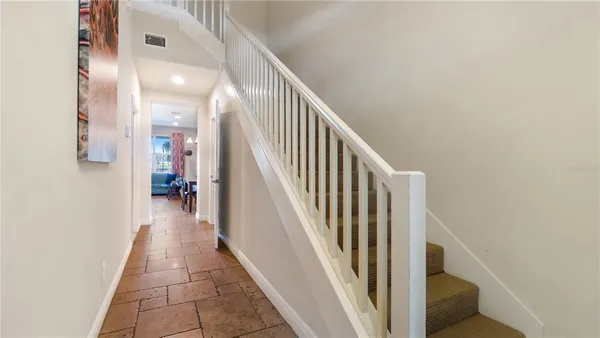 a view of a hallway with wooden floor and staircase