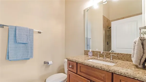 a bathroom with a granite countertop sink and a mirror
