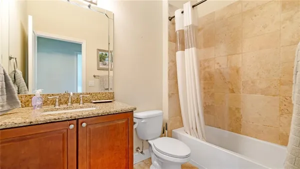 a bathroom with a granite countertop sink toilet and shower