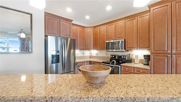 a kitchen with stainless steel appliances granite countertop a refrigerator stove top oven and sink