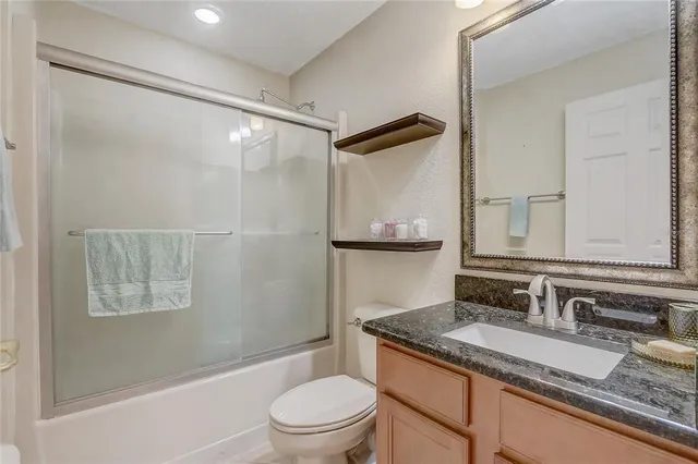 a bathroom with a granite countertop sink toilet and shower