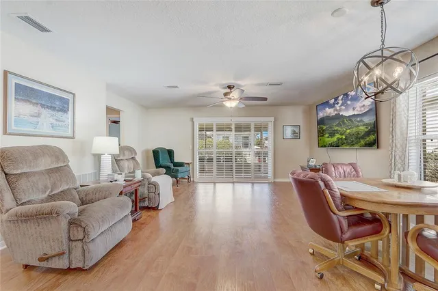 a living room with furniture a chandelier and a wooden floor