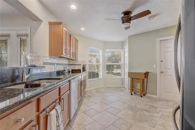 a kitchen with granite countertop a sink and a refrigerator