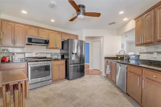 a kitchen with refrigerator a stove top oven a sink and dishwasher