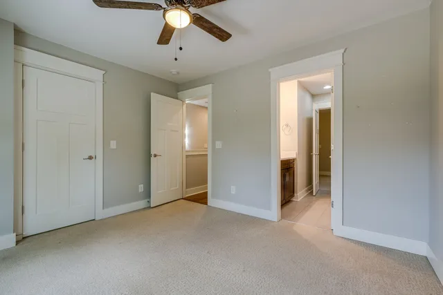 a view of an empty room and chandelier fan