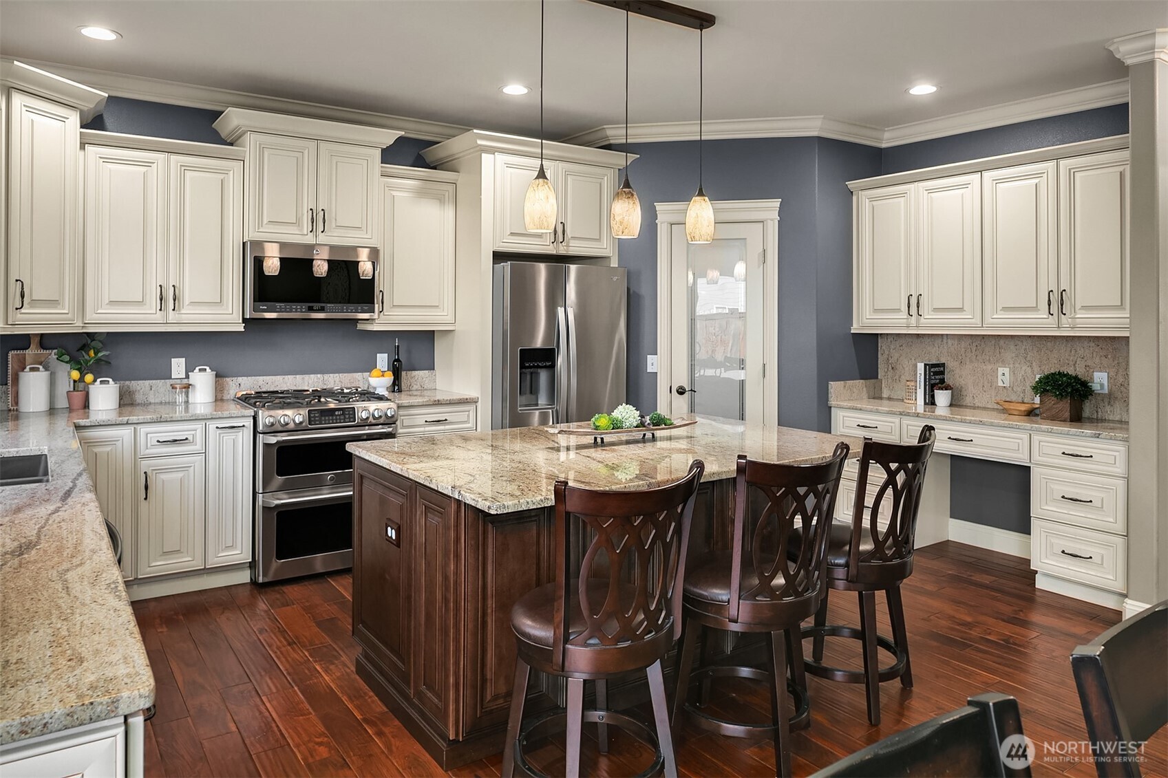 22632 Southeast 281st Street Maple Valley, WA 98038 - Photo 8 of 24 a kitchen with stainless steel appliances granite countertop a stove a refrigerator a sink a dining table and chairs