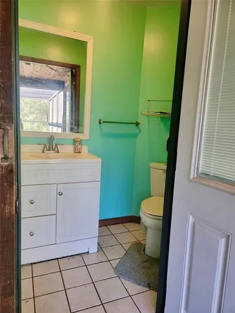 a bathroom with a granite countertop toilet sink and mirror