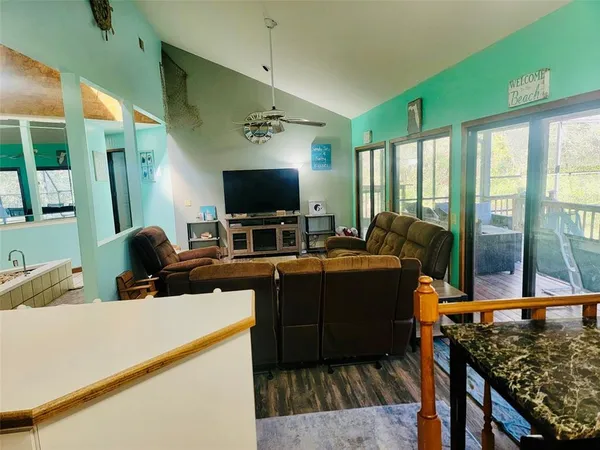 a living room with furniture a flat screen tv and a floor to ceiling window