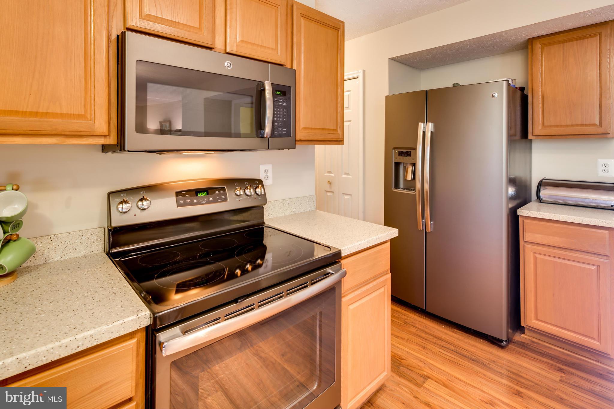 9539 Ridgeview Drive Columbia, MD 21046 - Photo 7 of 30 a kitchen with granite countertop cabinets and steel stainless steel appliances with wooden floor