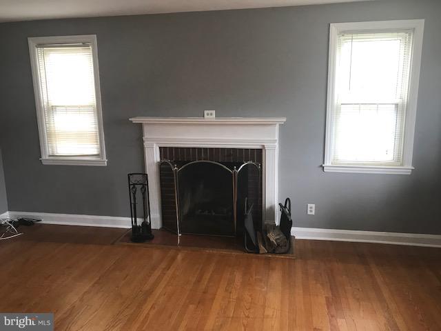 1001 Harwall Road Baltimore, MD 21207 - Photo 49 of 109 an empty room with wooden floor a fireplace and windows