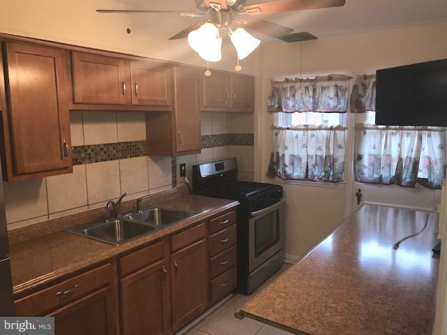 1001 Harwall Road Baltimore, MD 21207 - Photo 53 of 109 a kitchen with stainless steel appliances granite countertop a sink a stove and a wooden cabinets
