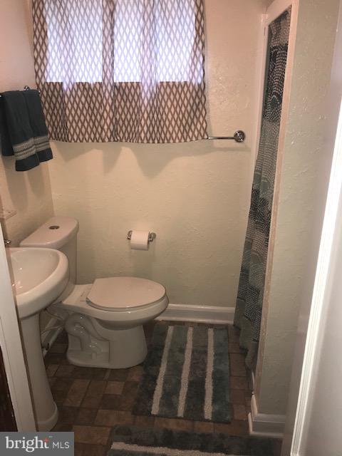 1001 Harwall Road Baltimore, MD 21207 - Photo 62 of 109 a white toilet sitting next to a shower curtain