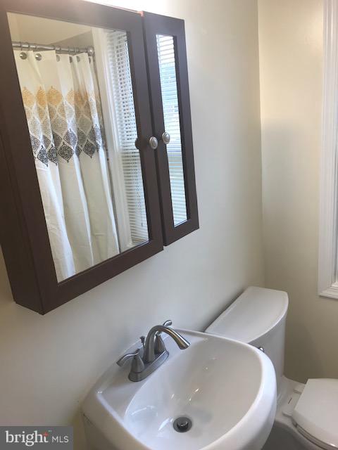1001 Harwall Road Baltimore, MD 21207 - Photo 65 of 109 a bathroom with a sink and mirror with toilet