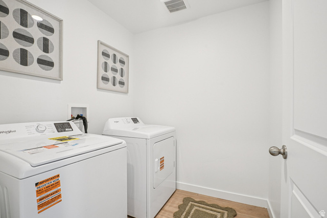 2097 North Ostler Peak Road, Unit 115 Heber City, UT 84032 - Photo 20 of 33 Dedicated laundry area featuring a washer and dryer, wood-finish flooring, and crisp white walls
