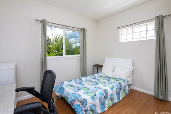 a bedroom with a bed a mirror and a window