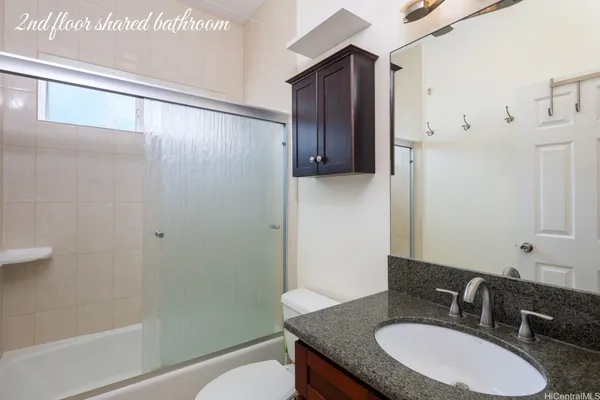 a bathroom with a granite countertop sink toilet and shower