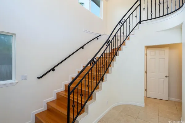 a view of staircase with wooden floor and white walls