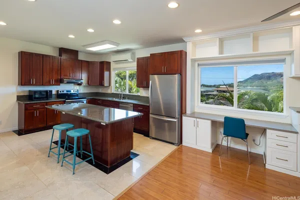 a kitchen with stainless steel appliances granite countertop a refrigerator a sink a stove a dining table and chairs