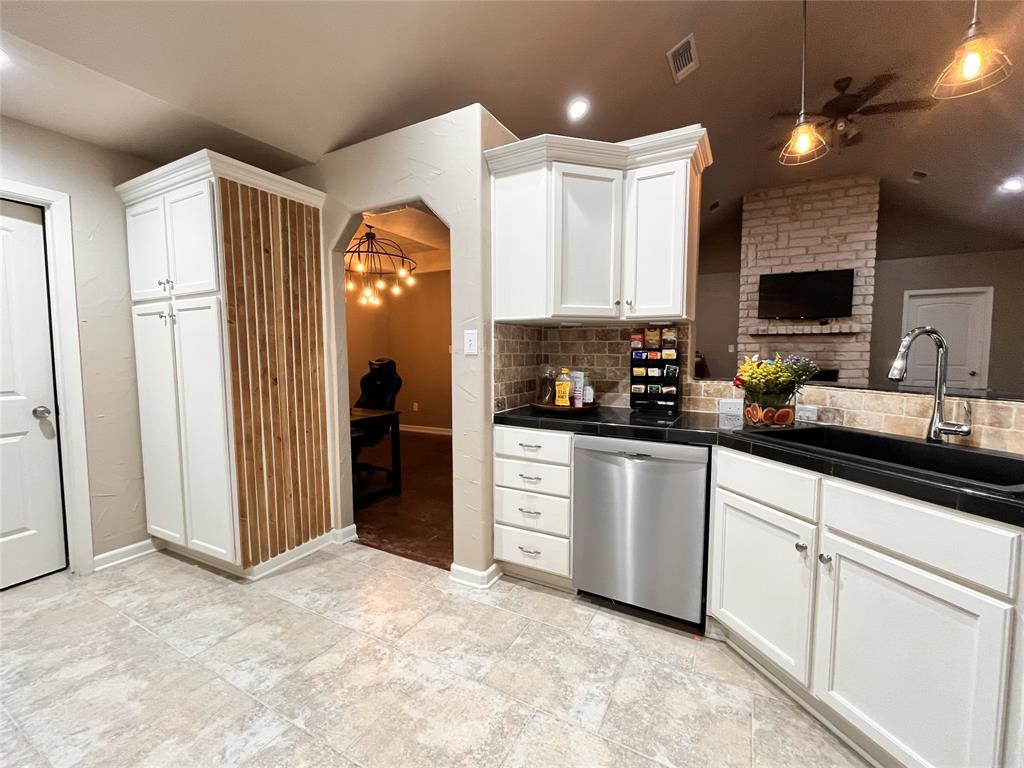 420 Sessums Road Springtown, TX 76082 - Photo 13 of 40 Kitchen with white cabinets, dishwasher, pendant lighting, lofted ceiling, and backsplash