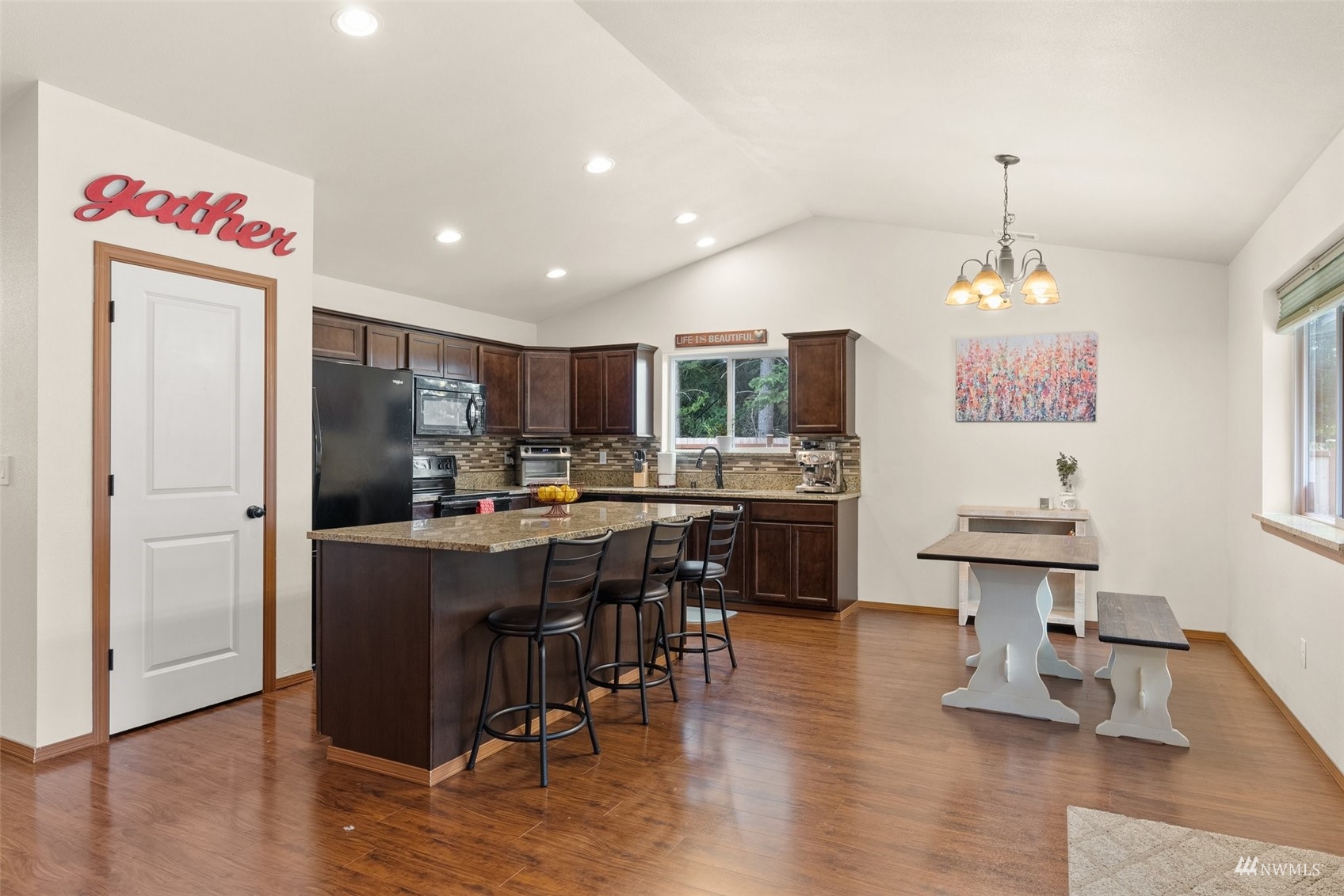 6320 192nd Lane Southwest Rochester, WA 98579 - Photo 11 of 30 a kitchen with stainless steel appliances kitchen island granite countertop a table chairs and a refrigerator