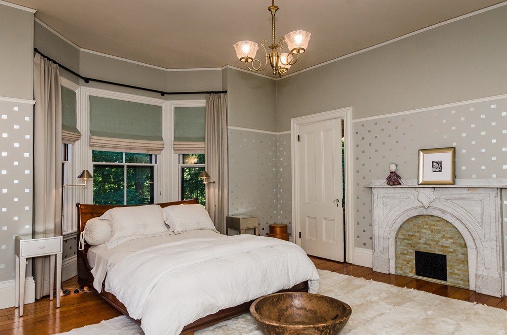 83 Elm Street Boston, MA 02130 - Photo 18 of 30 a spacious bedroom with a bed and a fireplace