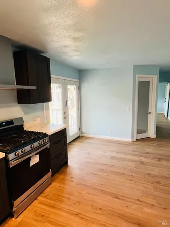 a kitchen with granite countertop a stove and a wooden floor