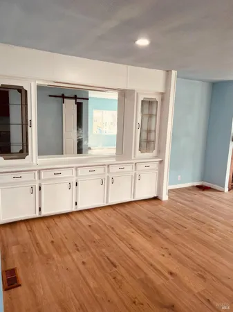 an empty room with mirror and windows